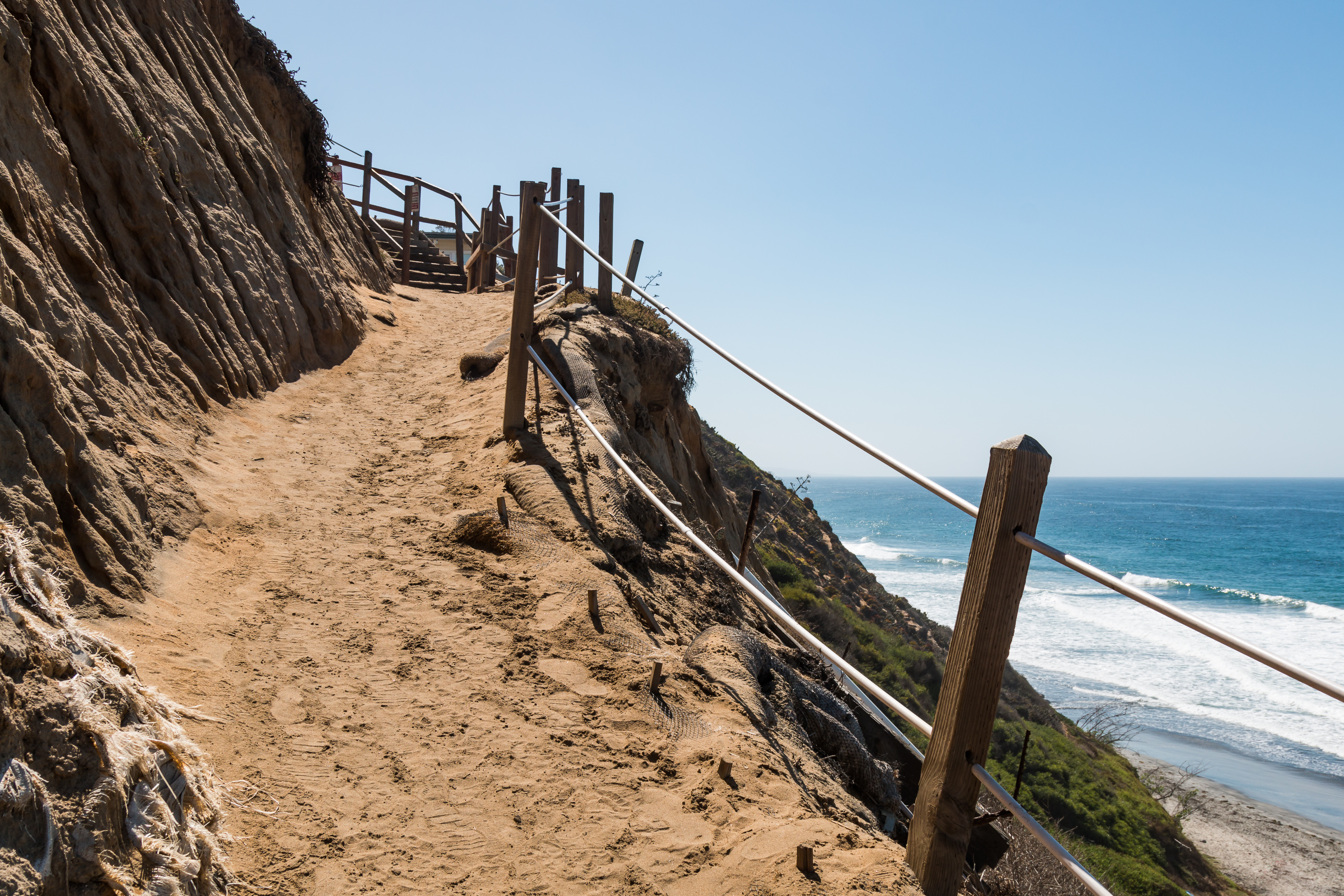 A dirt path on the side of a cliff headed down toward the beach at Beacon's Beach in Encinitas, California.